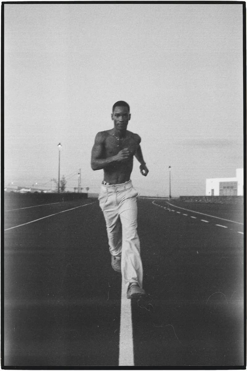 Man running down an empty road, black and white film photo