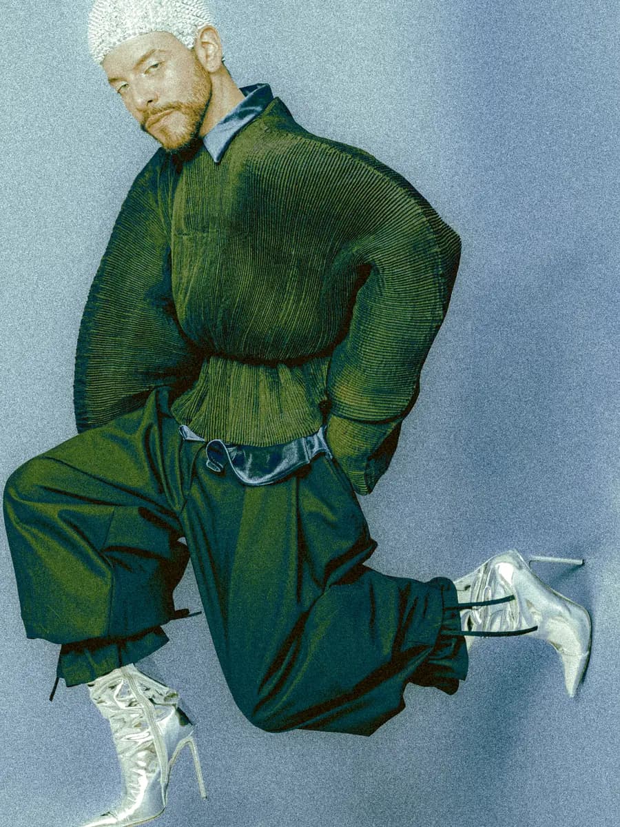 Portrait of a person kneeling in green pleated clothes and silver heels